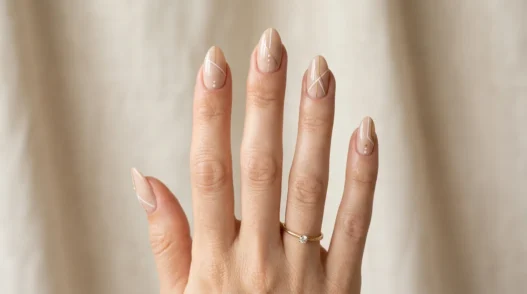 Woman's hand displaying variety of almond nail designs in elegant studio photography setup