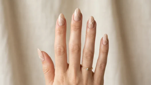 Woman's hand displaying variety of almond nail designs in elegant studio photography setup