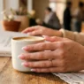 Woman's hand showing fresh classic almond nails with French tips in soft morning light