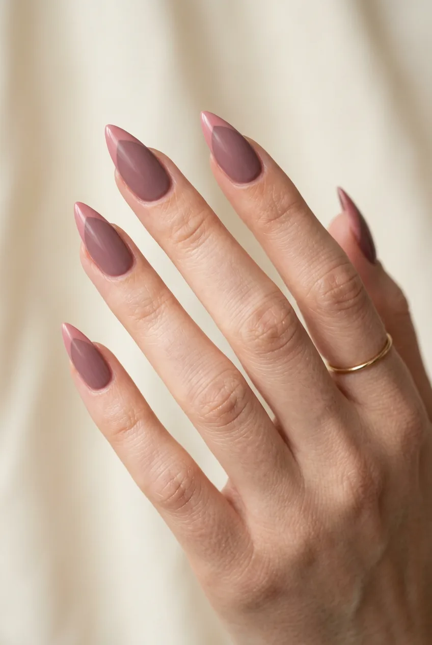 Pointed stiletto nails painted in soft dusty rose pink color with matte finish