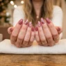 Woman's hands elegantly displayed on salon table showing freshly manicured nails with glossy finish