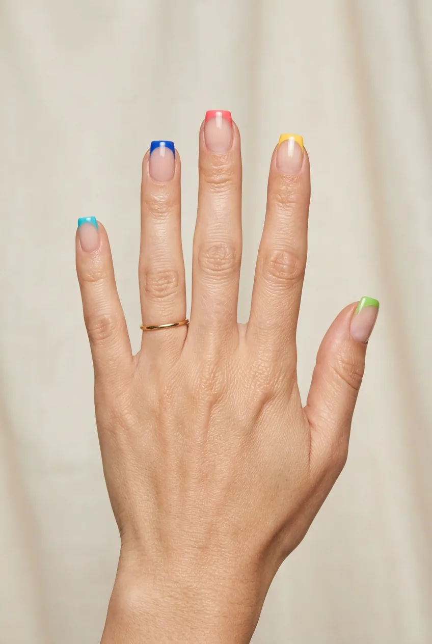 Clean french manicure base with bright colored tips instead of traditional white on squares