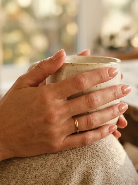 Woman's hand showing fresh natural manicure in soft golden hour lighting with shallow depth of field