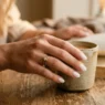 Woman's hand with milky white translucent manicure in soft golden hour lighting