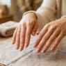 Woman's hands showing completed simple nude manicure with glossy finish on salon table