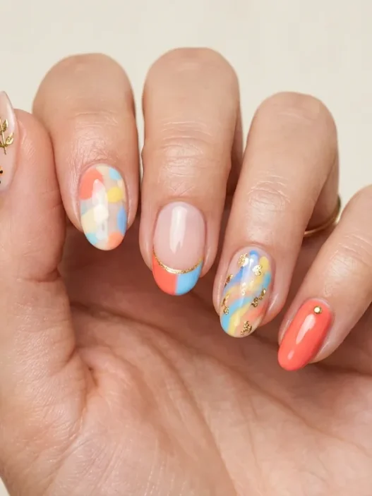 Woman's hand showing summer 2026 nail trends with mixed designs on each finger