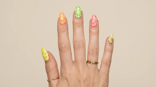 Woman's hand showing summer short nail designs with bright citrus colored tips on natural length nails