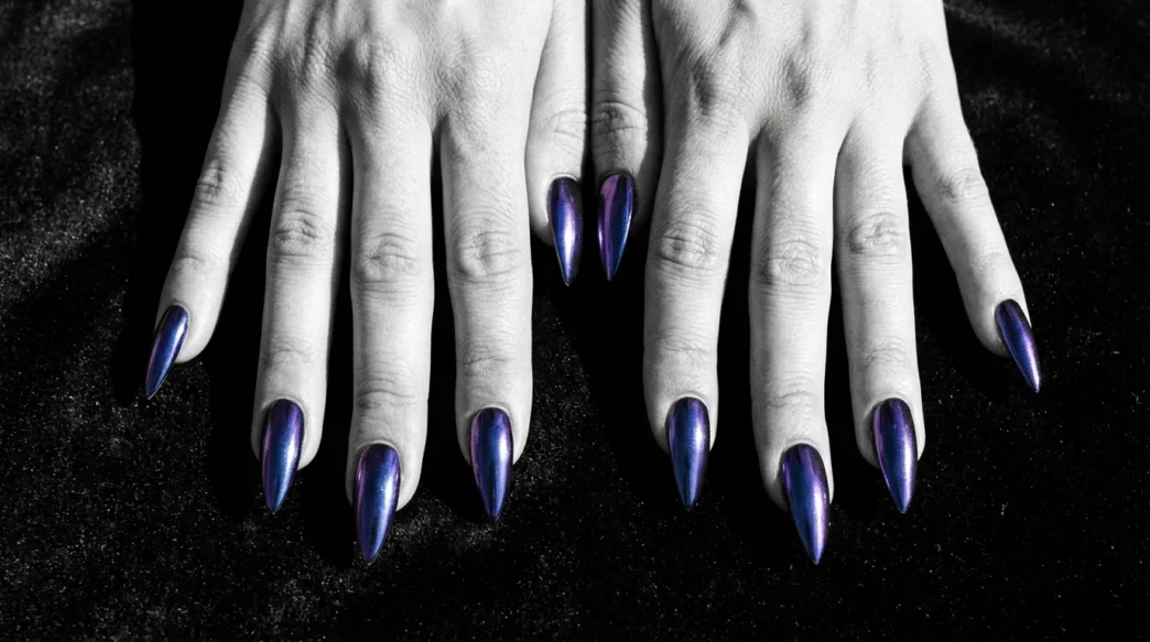 All ten stiletto nails fanned out showing deep midnight chrome finish that shifts cobalt to purple on dark velvet surface